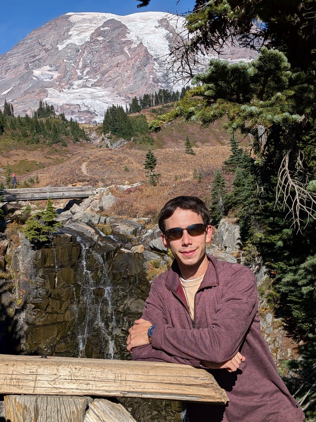 Me at a railing above a waterfall, Mount Rainier behind